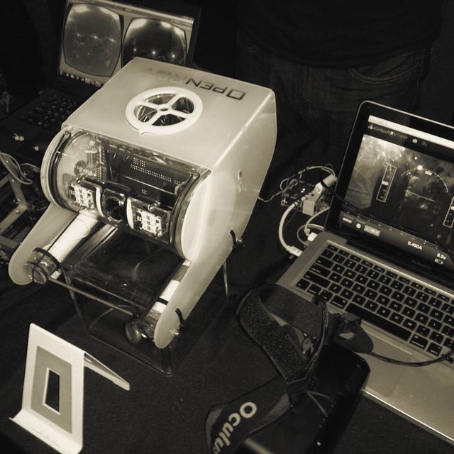 The OpenROV drone beside a laptop showing its camera feed, with an Oculus headset on the table.